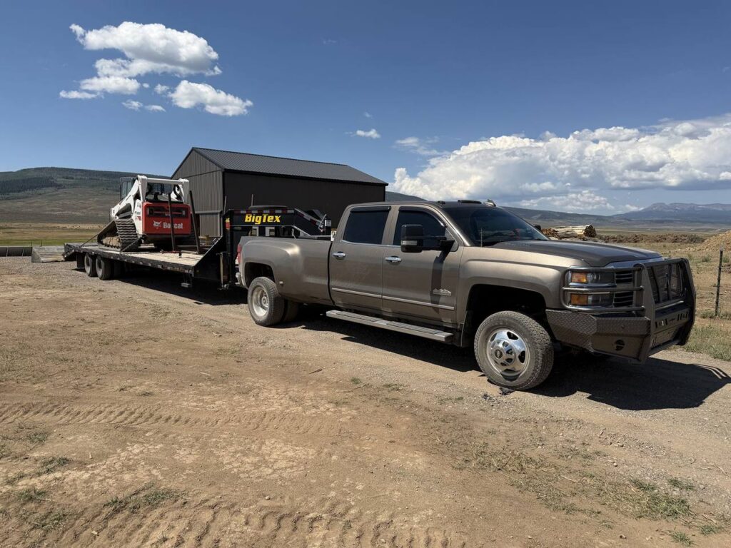 Dream Ridge truck and gooseneck trailer loaded with the Bobcat track loader